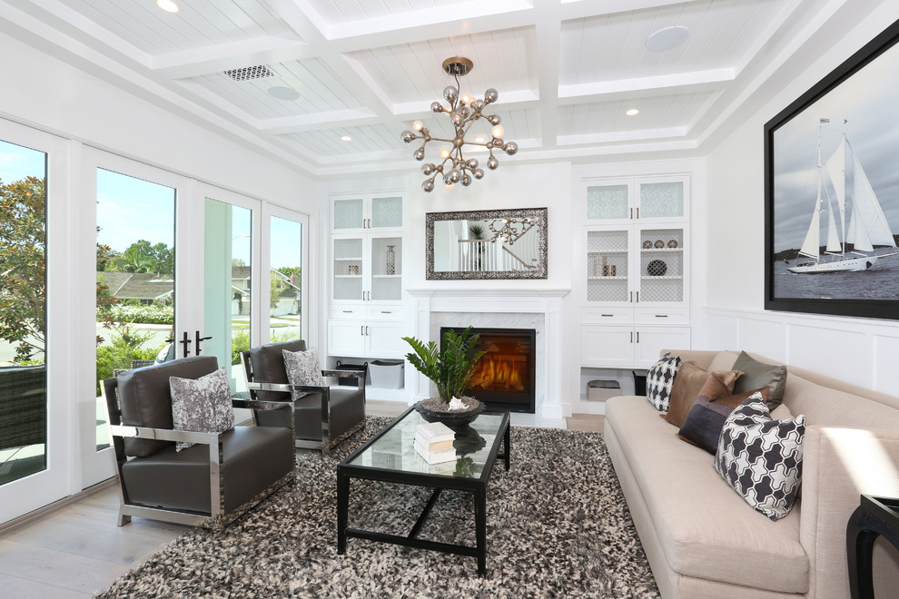 Inspiration for a traditional living room in Orange County with a standard fireplace, a stone fireplace surround, white walls and medium hardwood floors.