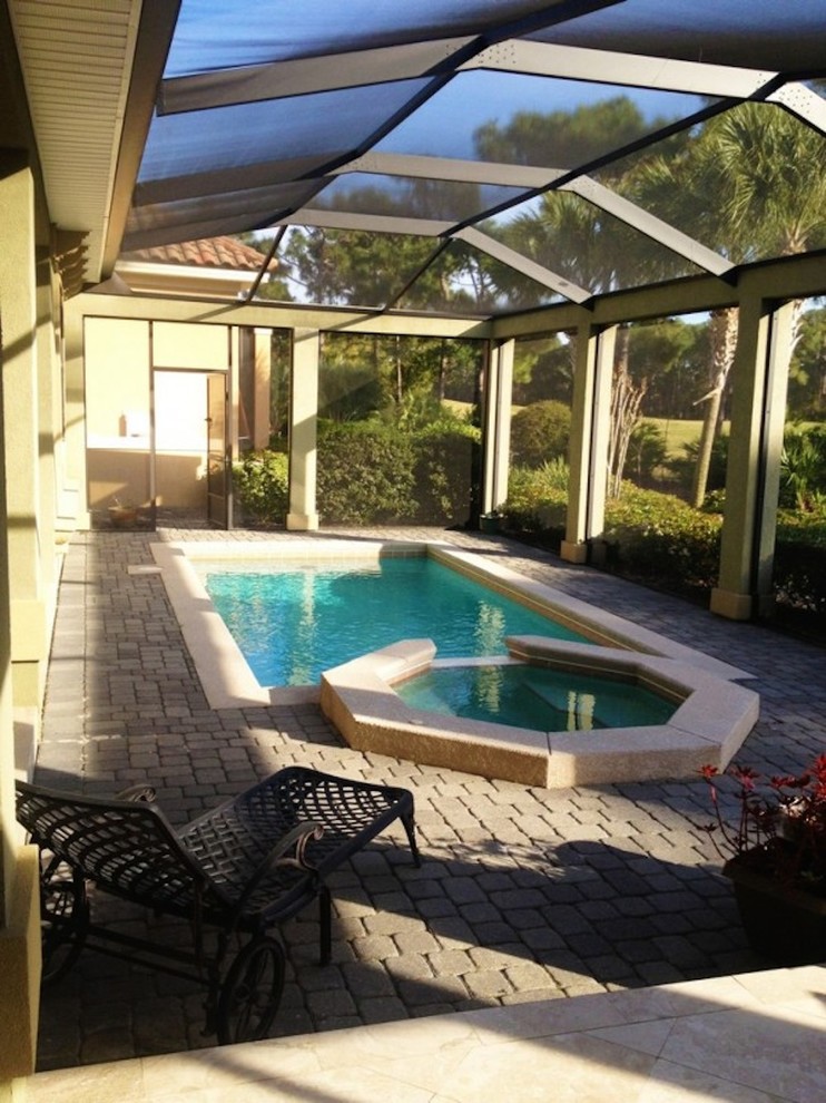 Photo of a mid-sized indoor custom-shaped pool in Miami with a hot tub and concrete pavers.