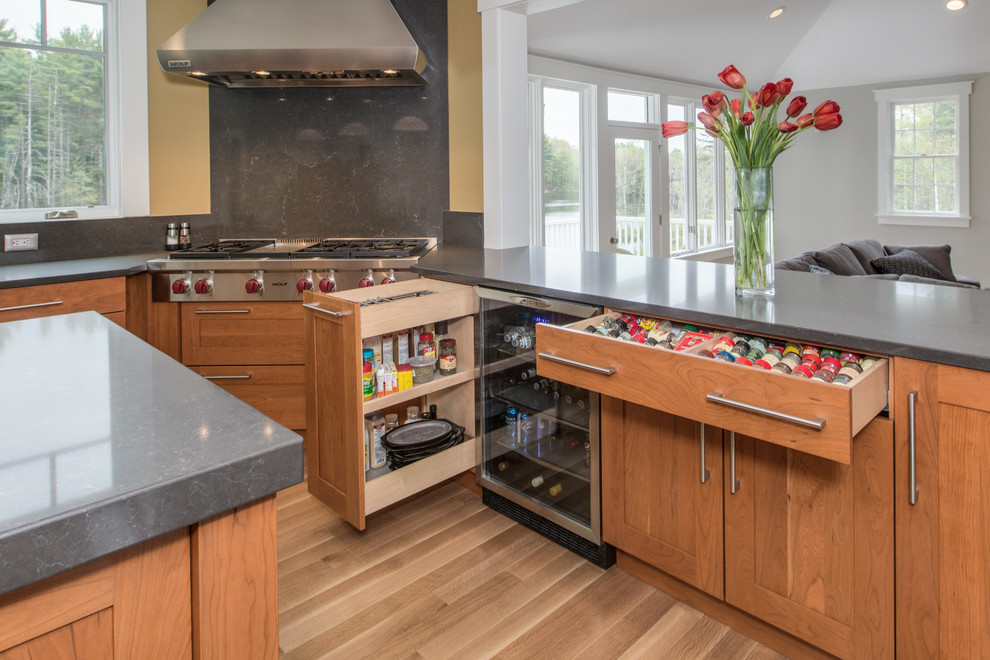 Example of a transitional u-shaped medium tone wood floor kitchen design in Boston with an undermount sink, shaker cabinets, medium tone wood cabinets, quartz countertops, gray backsplash, stone slab backsplash, stainless steel appliances and an island