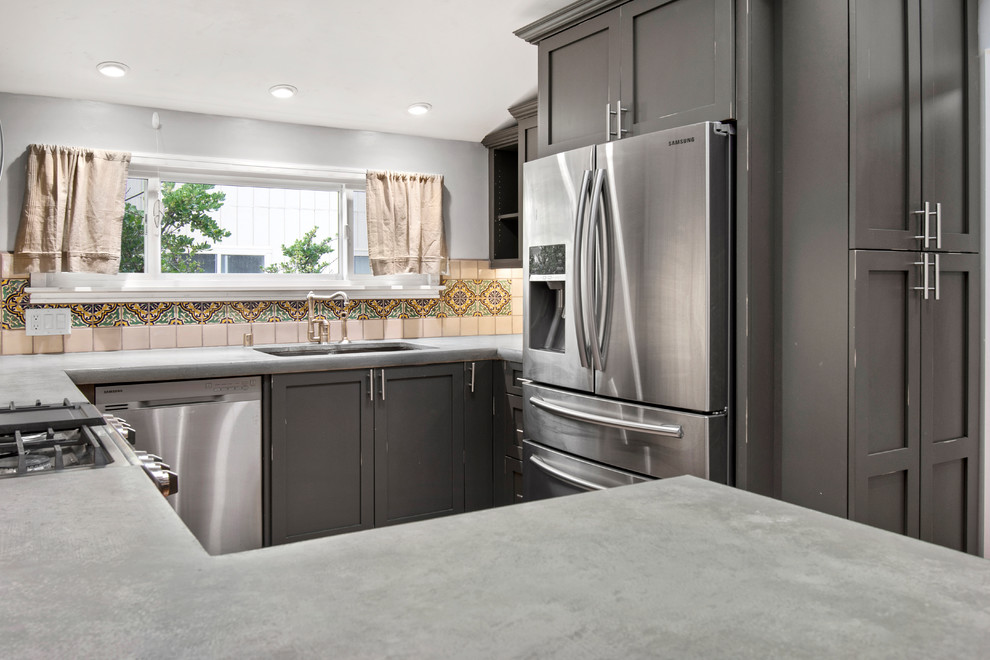 Inspiration for a small traditional u-shaped kitchen in San Francisco with an undermount sink, shaker cabinets, distressed cabinets, concrete benchtops, ceramic splashback, stainless steel appliances, medium hardwood floors, brown floor and grey benchtop.