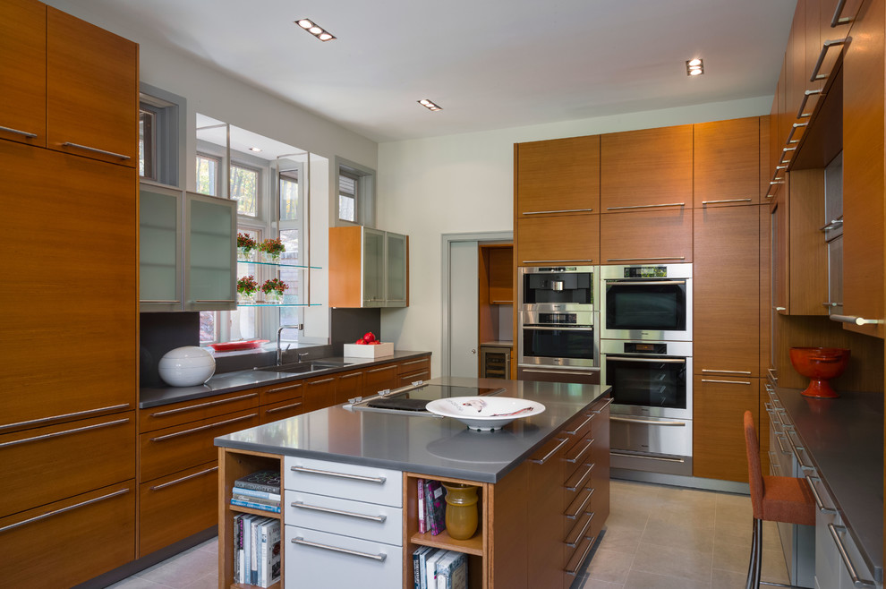 Mid-sized contemporary u-shaped separate kitchen in New York with an undermount sink, flat-panel cabinets, medium wood cabinets, grey splashback, panelled appliances and with island.