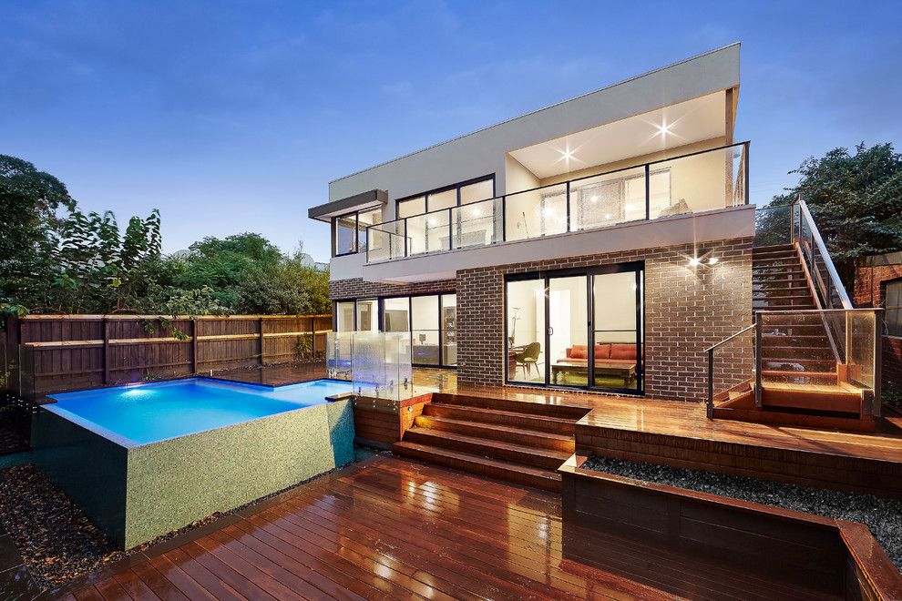 This is an example of an expansive modern one-storey exterior in Melbourne with mixed siding and a flat roof.