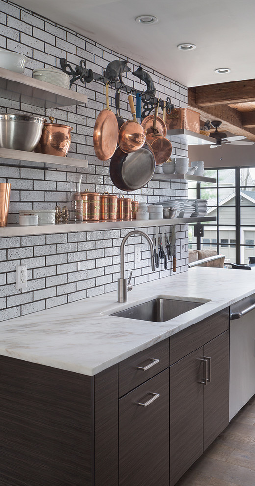 Design ideas for a mid-sized industrial galley open plan kitchen in Boston with an undermount sink, flat-panel cabinets, dark wood cabinets, marble benchtops, brick splashback, stainless steel appliances, light hardwood floors and no island.