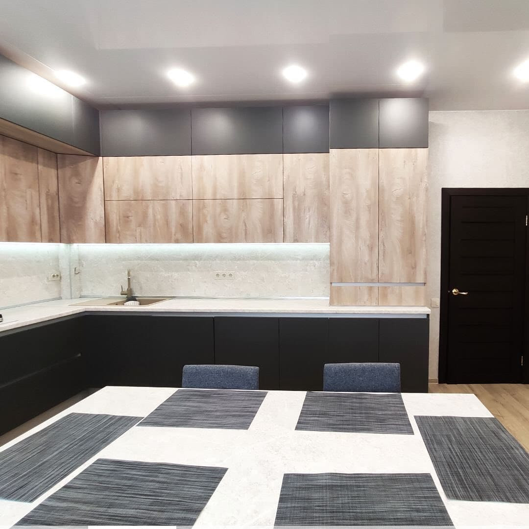Большая широкая угловая кухня с матовыми и древесными фасадами
