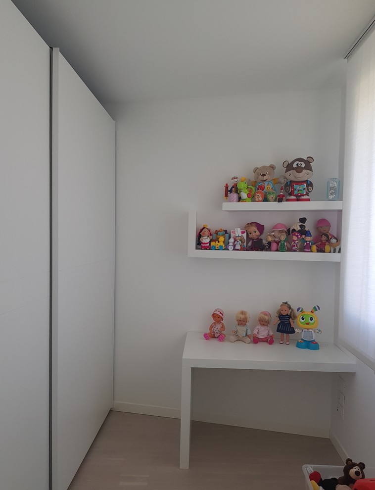 Small modern kids' bedroom in Milan with white walls, light hardwood floors and beige floor for kids 4-10 years old and girls.