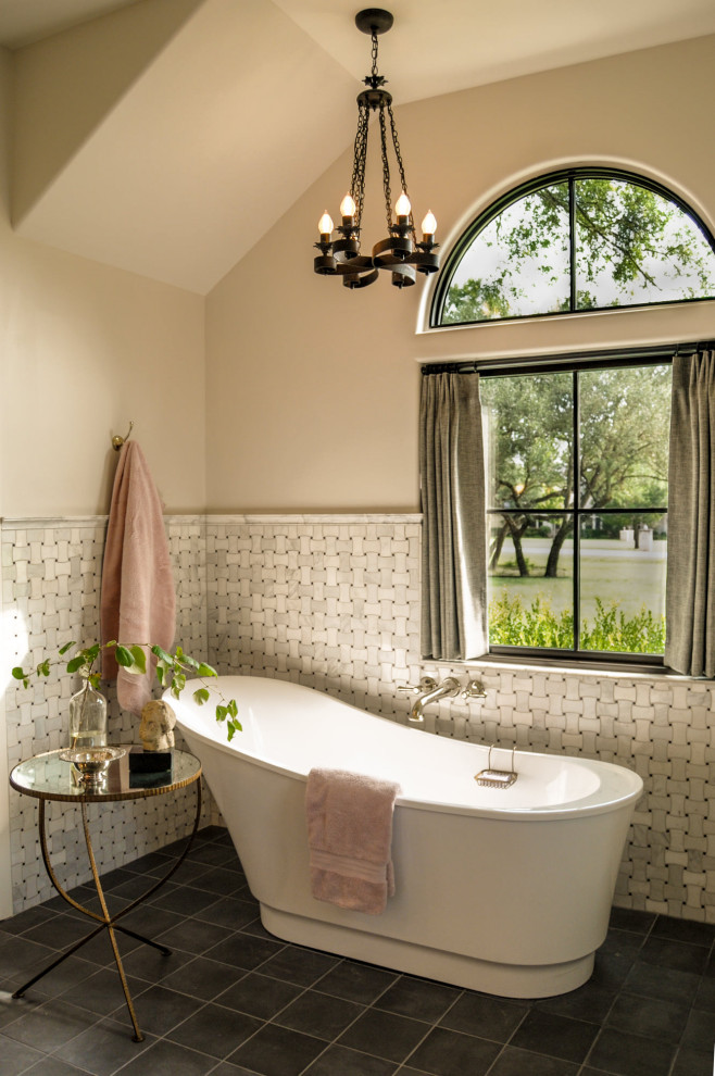 Cette photo montre une salle de bain montagne de taille moyenne avec une baignoire indépendante et un carrelage gris.