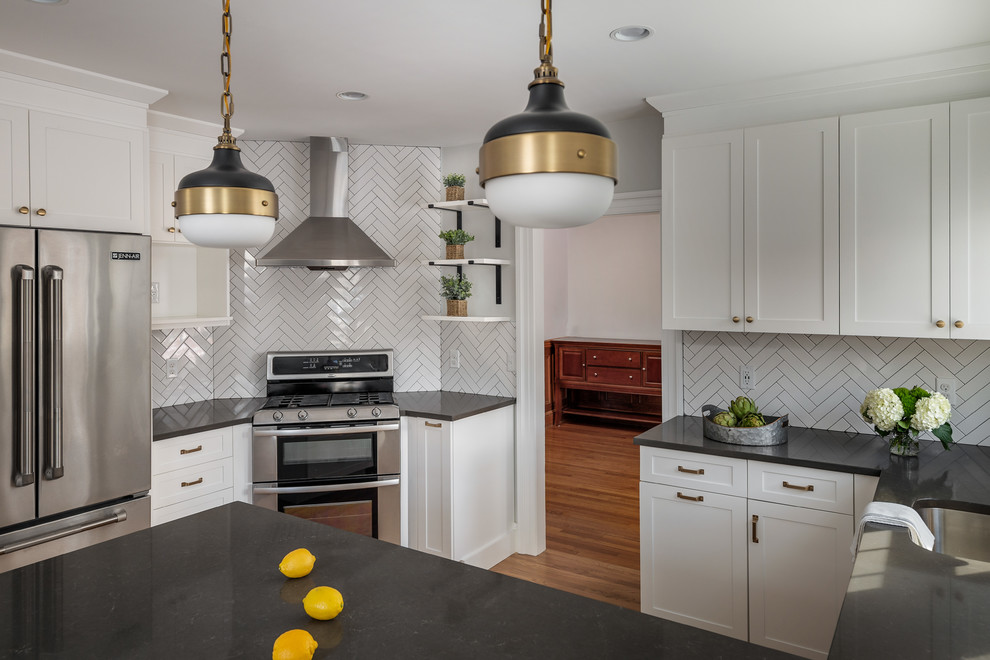 Enclosed kitchen - mid-sized transitional u-shaped light wood floor and brown floor enclosed kitchen idea in Boston with an undermount sink, shaker cabinets, white cabinets, quartz countertops, gray backsplash, ceramic backsplash, stainless steel appliances, a peninsula and gray countertops