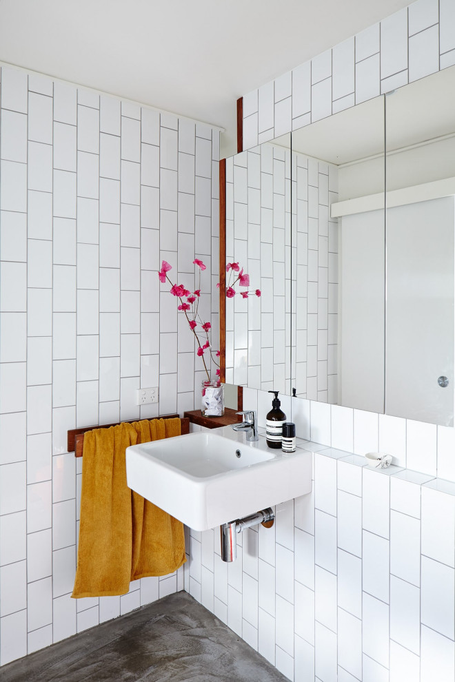 Design ideas for a contemporary bathroom in Sunshine Coast with white tile, subway tile, concrete floors, a wall-mount sink and grey floor.