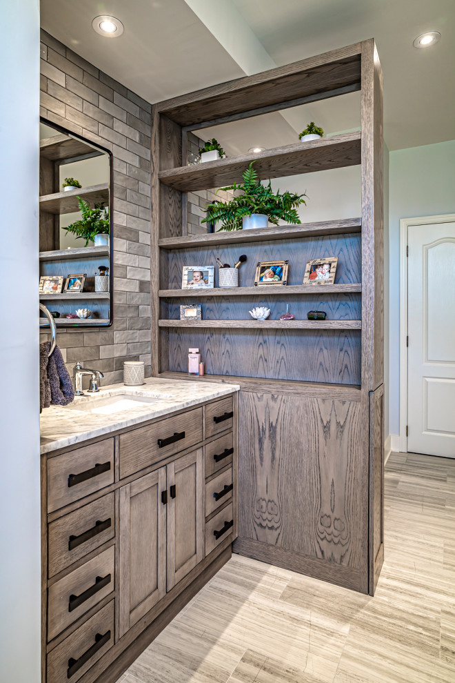 Example of a large transitional blue tile and ceramic tile gray floor and double-sink bathroom design with gray cabinets, gray walls, a drop-in sink, a hinged shower door, gray countertops and a niche