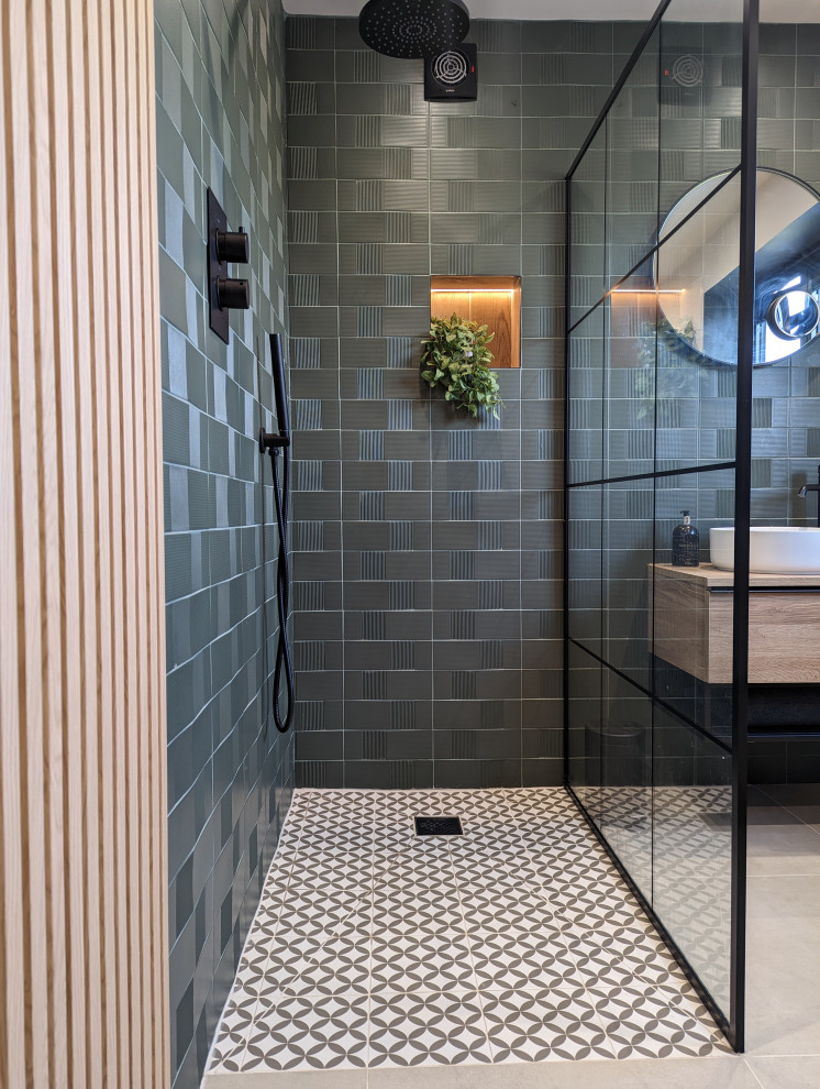 This is an example of a mid-sized contemporary master bathroom in Other with flat-panel cabinets, light wood cabinets, an open shower, a one-piece toilet, green walls, ceramic floors, an integrated sink, grey floor, an open shower, a single vanity, a floating vanity and panelled walls.