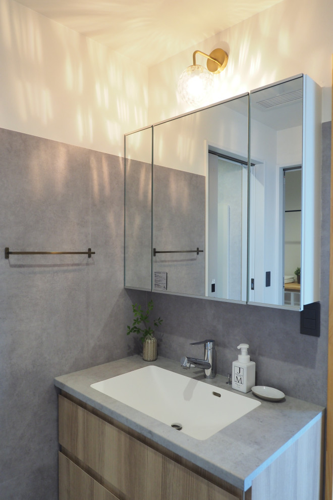 Modern cloakroom in Other with grey cabinets, a one-piece toilet, grey tiles, grey walls, brown worktops, feature lighting, a freestanding vanity unit and a wallpapered ceiling.