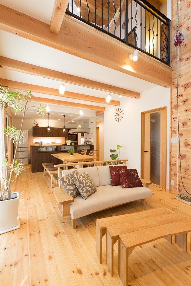 他の地域にあるアジアンスタイルのおしゃれなLDK (白い壁、淡色無垢フローリング、据え置き型テレビ、茶色い床) の写真