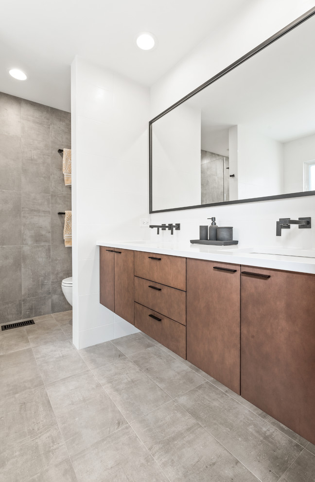 Design ideas for a mid-sized contemporary master wet room bathroom in Chicago with flat-panel cabinets, medium wood cabinets, a drop-in tub, a one-piece toilet, multi-coloured tile, marble, multi-coloured walls, an undermount sink, engineered quartz benchtops, a hinged shower door and white benchtops.