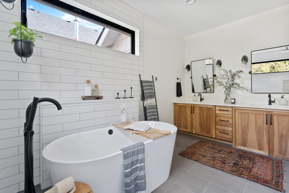 Inspiration for a large farmhouse master white tile and subway tile ceramic tile, gray floor and double-sink bathroom remodel in Portland with shaker cabinets, brown cabinets, a one-piece toilet, white walls, an undermount sink, quartzite countertops, white countertops and a built-in vanity