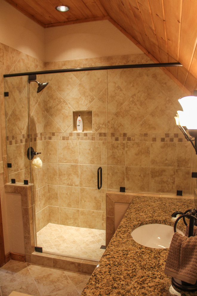 Esempio di una stanza da bagno con doccia rustica di medie dimensioni con lavabo sottopiano, ante con riquadro incassato, ante in legno scuro, top in granito, doccia alcova, piastrelle beige, piastrelle in ceramica e pavimento con piastrelle in ceramica