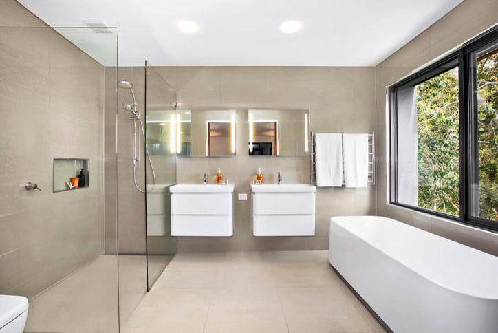 Expansive contemporary master bathroom in Sydney with a freestanding tub, an open shower, a one-piece toilet, cement tile, beige walls, ceramic floors and a console sink.