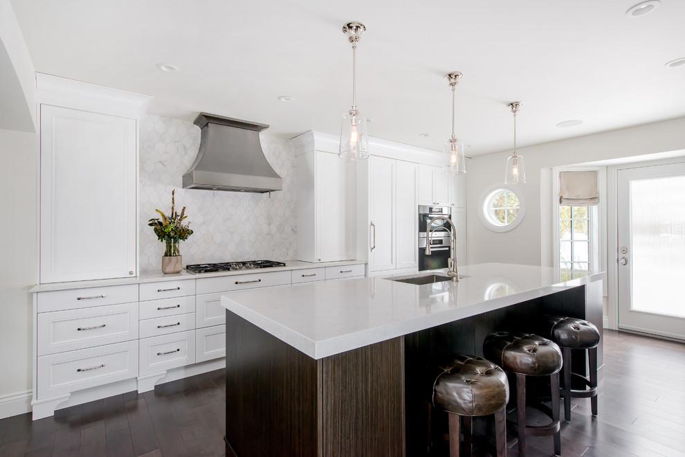 Example of a large transitional single-wall dark wood floor and brown floor eat-in kitchen design in Calgary with white cabinets, quartz countertops, an island, an undermount sink, multicolored backsplash, stone tile backsplash, paneled appliances and recessed-panel cabinets