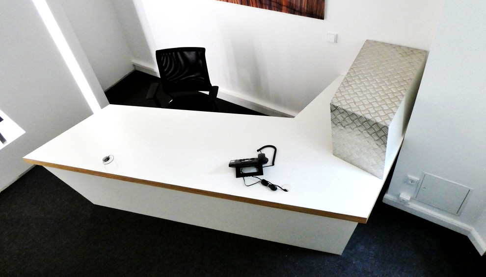 Modernes Arbeitszimmer mit Arbeitsplatz, weißer Wandfarbe, Teppichboden, freistehendem Schreibtisch und grauem Boden
