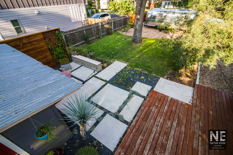 This is an example of a mid-sized rustic drought-tolerant backyard concrete paver landscaping in Austin.
