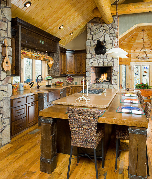 Large mountain style medium tone wood floor eat-in kitchen photo with a farmhouse sink, raised-panel cabinets, medium tone wood cabinets, concrete countertops, brown backsplash, terra-cotta backsplash and an island