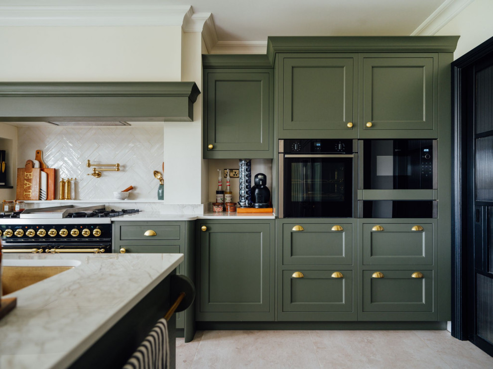 Klassisk inredning av ett stort flerfärgad flerfärgat kök, med en undermonterad diskho, luckor med profilerade fronter, gröna skåp, bänkskiva i kvartsit, flerfärgad stänkskydd, svarta vitvaror och en köksö