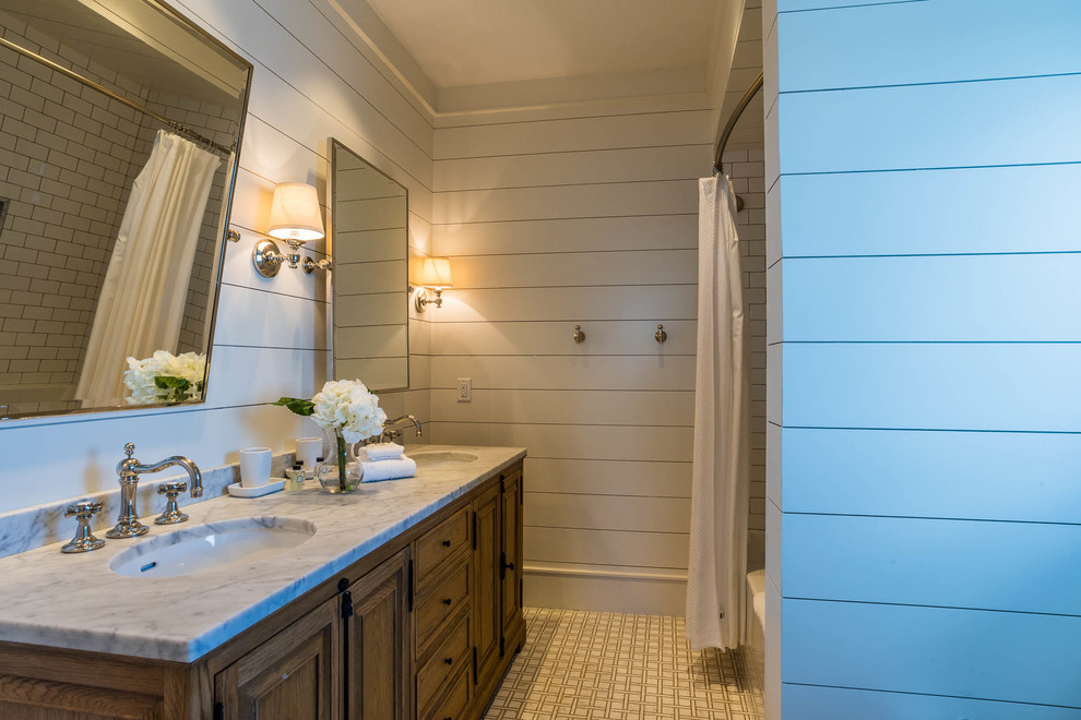 This is an example of a mid-sized beach style bathroom in Miami with furniture-like cabinets, medium wood cabinets, an alcove shower, white tile, porcelain tile, white walls, mosaic tile floors, an undermount sink and marble benchtops.