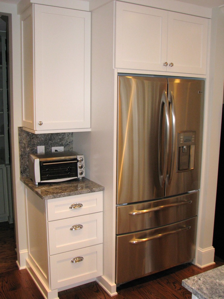 Eat-in kitchen - transitional l-shaped eat-in kitchen idea in Chicago with an undermount sink, shaker cabinets, white cabinets, granite countertops, stone slab backsplash and stainless steel appliances