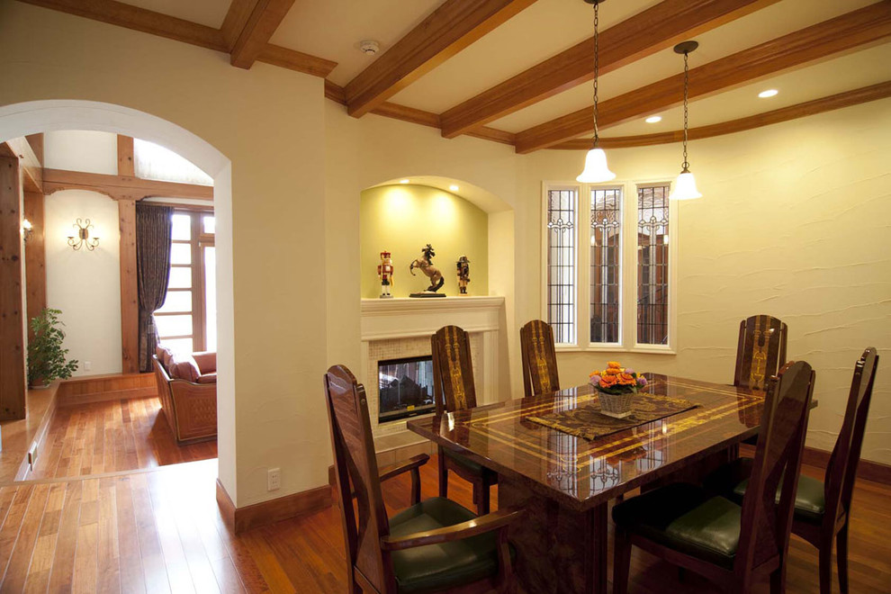 This is an example of a traditional separate dining room in Tokyo Suburbs with white walls, medium hardwood floors, a standard fireplace and brown floor.