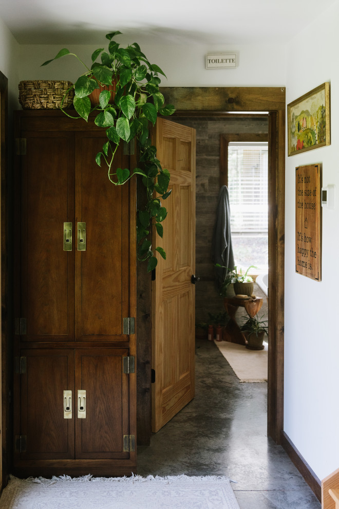 Стильный дизайн: маленькое фойе в стиле рустика с белыми стенами, бетонным полом, одностворчатой входной дверью, черной входной дверью, серым полом и балками на потолке для на участке и в саду - последний тренд