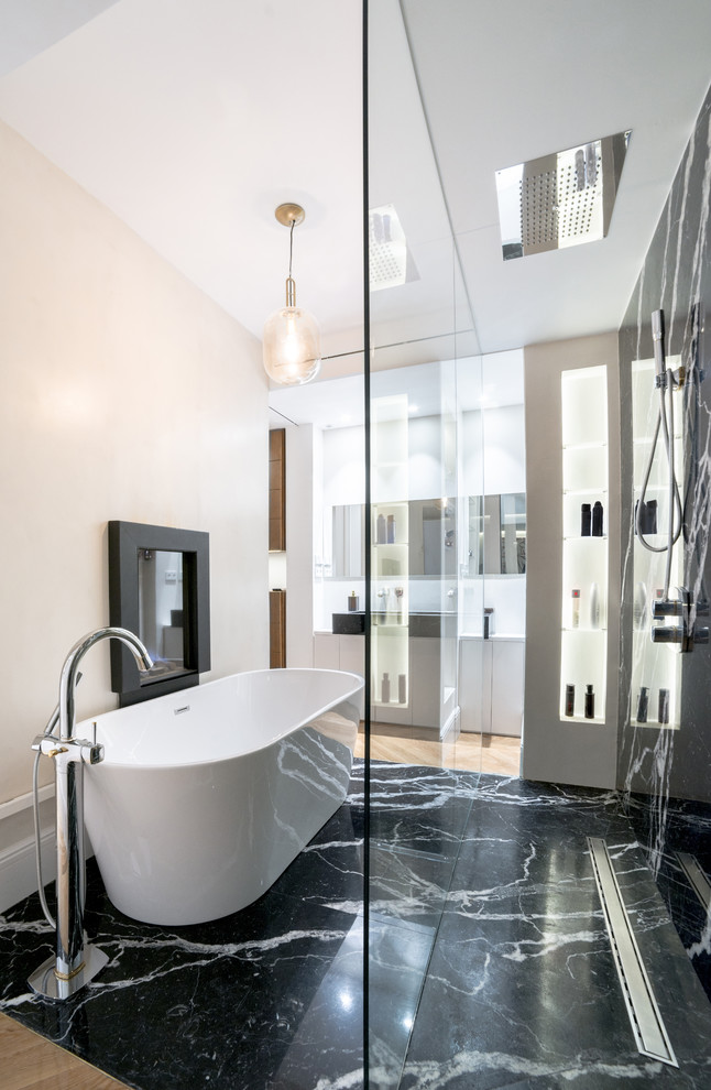 Photo of a contemporary master bathroom in Madrid with flat-panel cabinets, white cabinets, a freestanding tub, a curbless shower, beige walls, marble floors, a vessel sink, black floor and white benchtops.