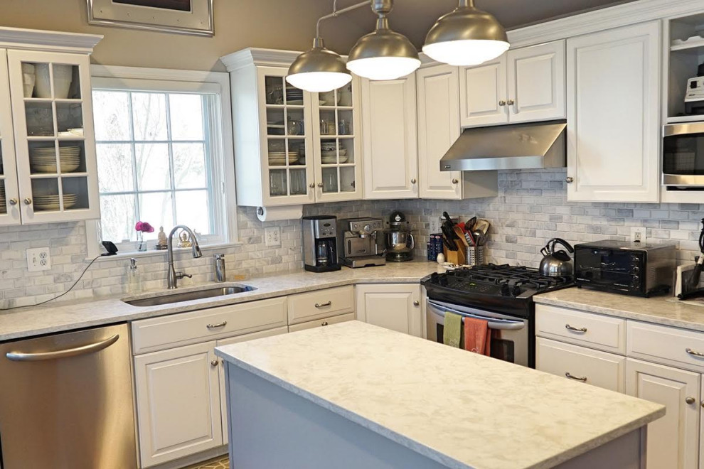 Example of a mid-sized transitional u-shaped medium tone wood floor and brown floor eat-in kitchen design in Sacramento with an undermount sink, white cabinets, quartz countertops, gray backsplash, stainless steel appliances and an island