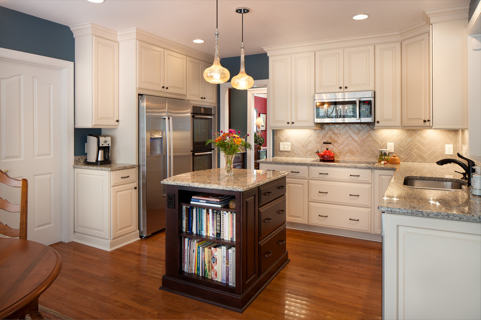 Small elegant u-shaped medium tone wood floor eat-in kitchen photo in Charlotte with an undermount sink, raised-panel cabinets, white cabinets, granite countertops, brown backsplash, ceramic backsplash, stainless steel appliances and an island