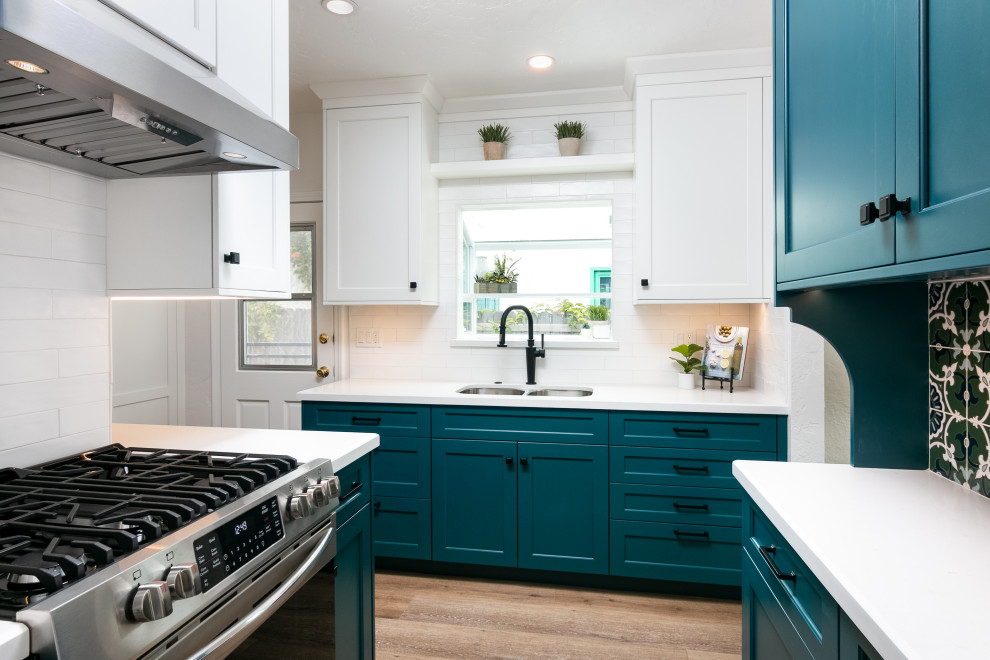 Small transitional l-shaped separate kitchen in Los Angeles with an undermount sink, shaker cabinets, blue cabinets, quartz benchtops, multi-coloured splashback, ceramic splashback, stainless steel appliances, vinyl floors, no island, brown floor and white benchtop.