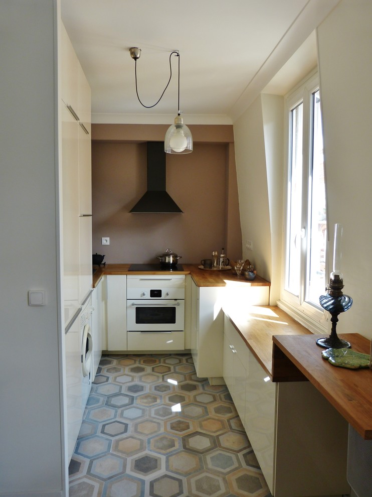 Small transitional u-shaped open plan kitchen in Paris with flat-panel cabinets, white cabinets, wood benchtops, brown splashback, white appliances and no island.
