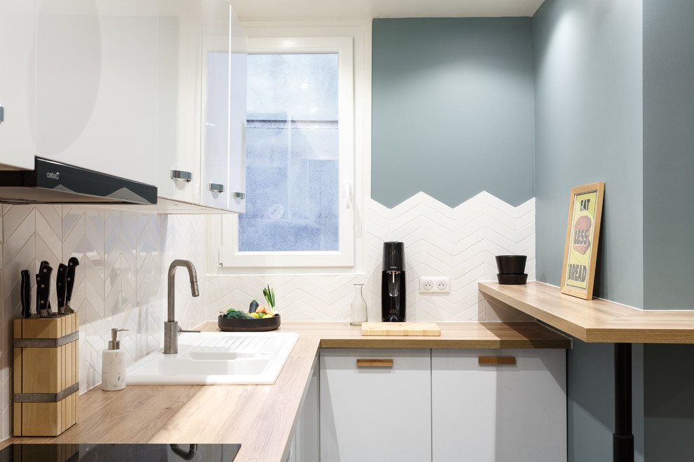 Design ideas for a small scandinavian l-shaped kitchen in Paris with a drop-in sink, flat-panel cabinets, white cabinets, wood benchtops, white splashback and beige benchtop.