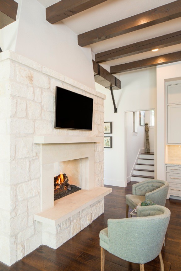 Mid-sized transitional open concept family room in Austin with dark hardwood floors, white walls, a standard fireplace, a plaster fireplace surround, a wall-mounted tv and brown floor.