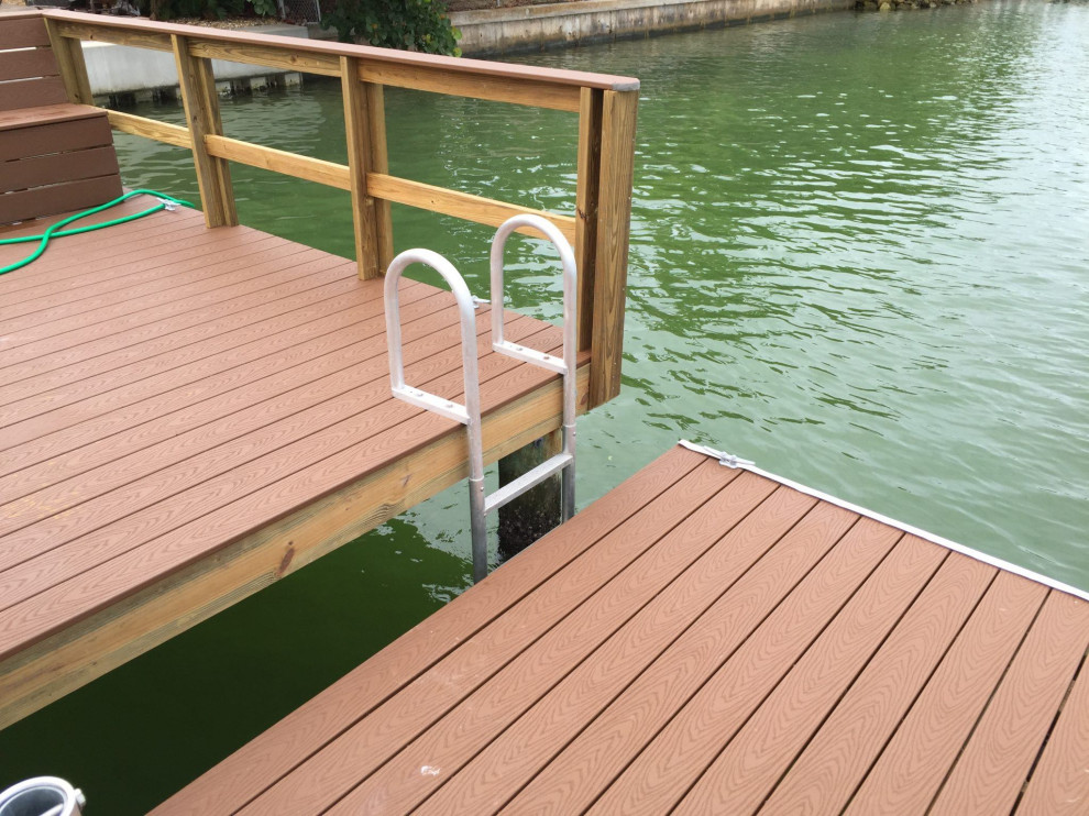 Small tropical backyard deck in Tampa with with dock and no cover.