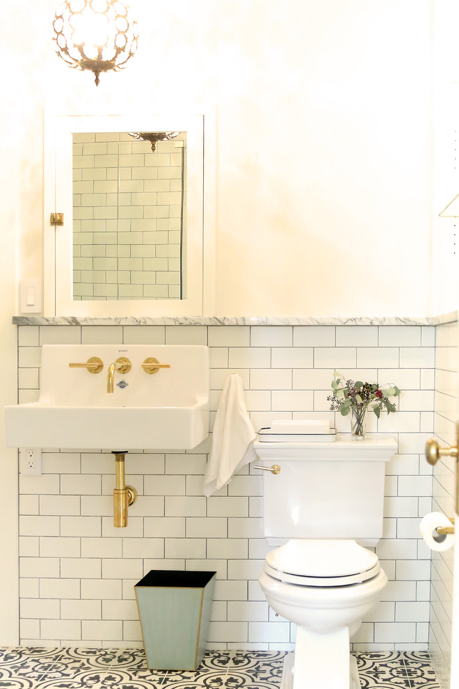 Design ideas for a small transitional 3/4 bathroom in Seattle with open cabinets, white cabinets, a corner shower, a two-piece toilet, white tile, subway tile, white walls, porcelain floors, a wall-mount sink, marble benchtops, black floor and a hinged shower door.