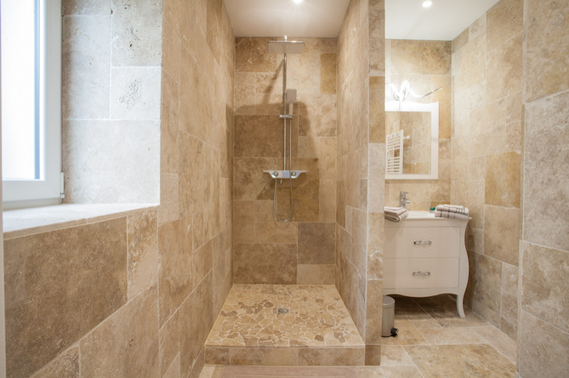 Modelo de cuarto de baño único nórdico de tamaño medio con ducha abierta, suelo de travertino y piedra
