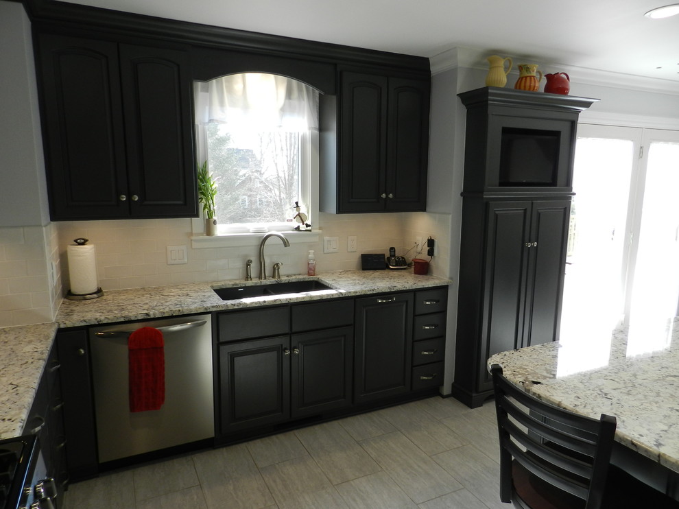 Enclosed kitchen - mid-sized transitional l-shaped porcelain tile and beige floor enclosed kitchen idea in Cleveland with an undermount sink, raised-panel cabinets, gray cabinets, granite countertops, white backsplash, subway tile backsplash, stainless steel appliances and an island