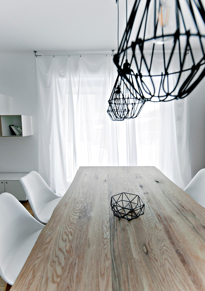 Exemple d'une grande salle à manger ouverte sur le salon tendance avec un mur blanc et un sol en bois brun.