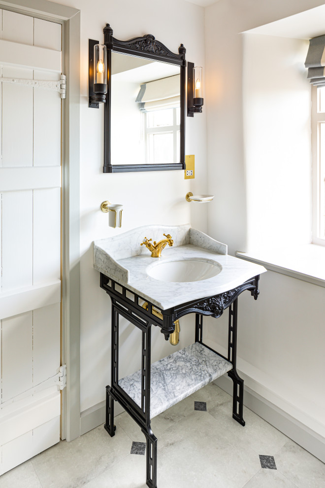 Photo of a mid-sized traditional master bathroom in Gloucestershire with raised-panel cabinets, dark wood cabinets, a freestanding tub, an open shower, a one-piece toilet, beige tile, porcelain tile, multi-coloured walls, vinyl floors, a vessel sink, marble benchtops, multi-coloured floor, an open shower, pink benchtops, a double vanity, a freestanding vanity and exposed beam.