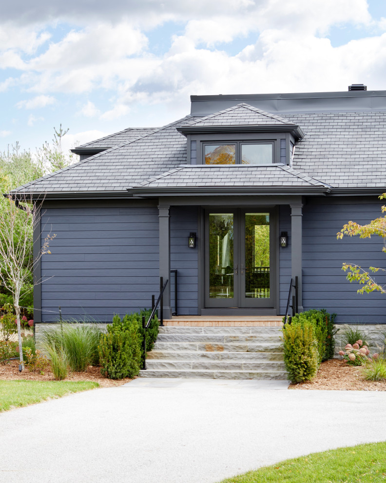 Design ideas for a large transitional split-level blue house exterior in Toronto with wood siding, a gambrel roof, a shingle roof, a black roof and clapboard siding.