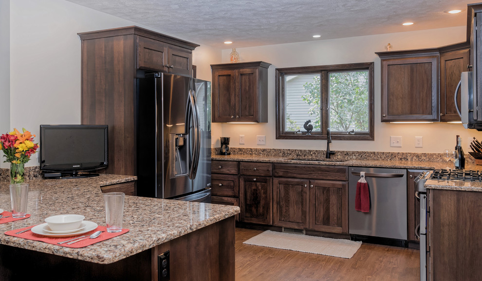 Mid-sized transitional l-shaped dark wood floor and brown floor eat-in kitchen photo in Grand Rapids with an undermount sink, recessed-panel cabinets, dark wood cabinets, quartz countertops, beige backsplash, stainless steel appliances, a peninsula and beige countertops