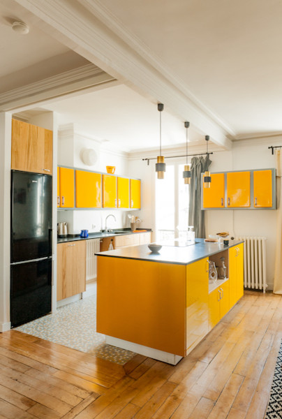 Photo of a mid-sized contemporary galley eat-in kitchen in Paris with an integrated sink, raised-panel cabinets, yellow cabinets, granite benchtops, white splashback, ceramic splashback, panelled appliances, terrazzo floors and with island.