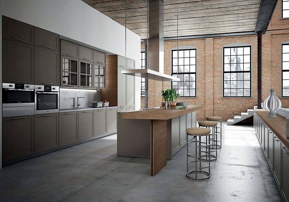 This is an example of a large industrial galley open plan kitchen in New York with shaker cabinets, medium wood cabinets, wood benchtops, concrete floors, multiple islands and grey floor.