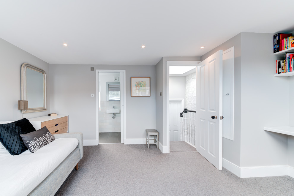 Photo of a mid-sized modern guest bedroom in London with grey walls, carpet and grey floor.