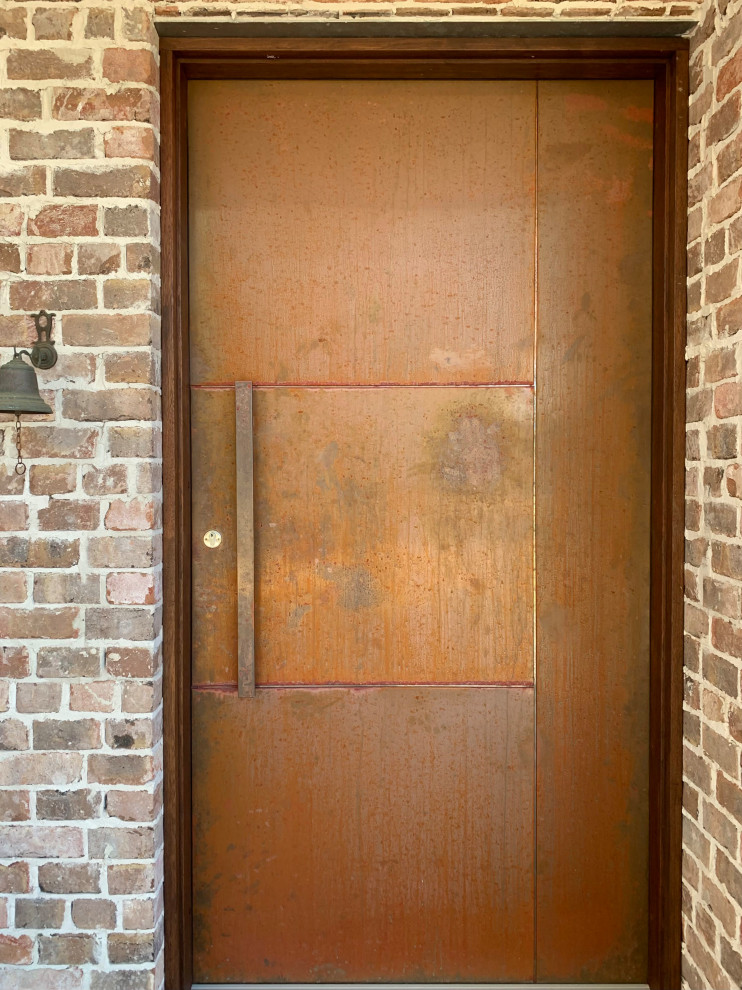Exempel på en stor modern ingång och ytterdörr, med orange väggar, klinkergolv i keramik, en pivotdörr, metalldörr och grått golv