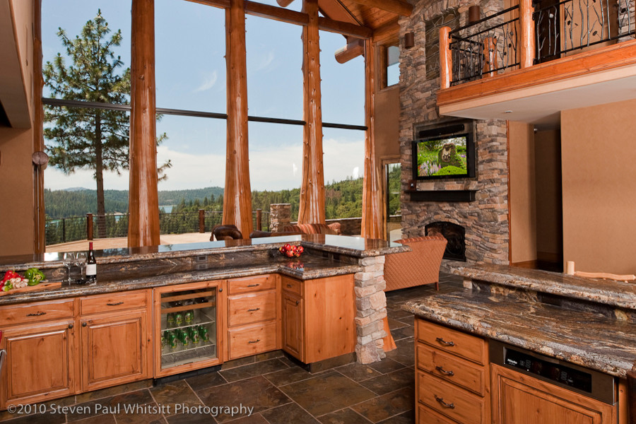 Open concept kitchen - huge rustic u-shaped slate floor open concept kitchen idea with an undermount sink, raised-panel cabinets, distressed cabinets, granite countertops, multicolored backsplash, stone slab backsplash, stainless steel appliances and a peninsula