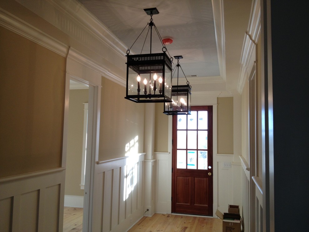 Inspiration for a large traditional foyer in Charlotte with beige walls, light hardwood floors, a single front door and a dark wood front door.
